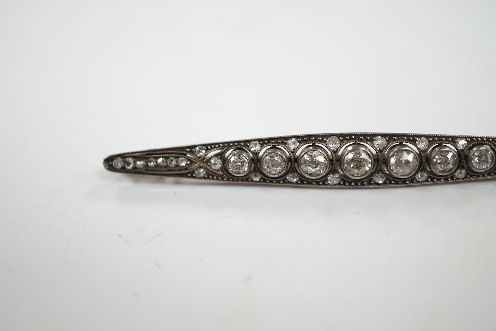 An Eastern European yellow metal (stamped 585) and white metal (stamped 875) and graduated diamond set bar brooch, 65mm, gross 5.1 grams. Condition - fair